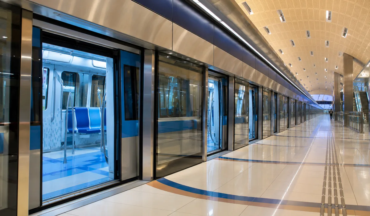 Dubai Metro train arriving at an elevated station at sunset
